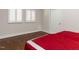 Bedroom featuring hardwood floors, two windows with white shutters, and red and white bedding at 222 Kelso Ct, Cary, NC 27511