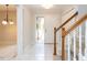 Bright foyer featuring tile flooring, a staircase with wood railings, and neutral paint at 222 Kelso Ct, Cary, NC 27511