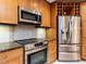 Close up on kitchen appliances featuring wood cabinets, granite counters, stainless steel appliances, and tile backsplash at 222 Kelso Ct, Cary, NC 27511