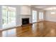 Bright living room featuring hardwood floors, fireplace, and seamless access to outdoor spaces at 222 Kelso Ct, Cary, NC 27511