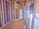 Hallway framing shows the unfinished studs, wiring, and new door to the exterior at 223 Pond Vw Ct # 10, Fuquay Varina, NC 27526