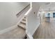 Carpeted staircase with white walls leading to an open-concept living space with hardwood flooring at 223 Pond Vw Ct # 10, Fuquay Varina, NC 27526