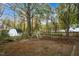 Large backyard featuring mature trees, shed, and play area, offering ample space for recreation and relaxation at 2256 W Front St, Burlington, NC 27215