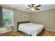 Bedroom features wood floors, a ceiling fan, and a large window providing natural light at 2256 W Front St, Burlington, NC 27215