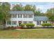 Charming two-story home featuring classic shutters, a well-manicured lawn, and lush landscaping at 2256 W Front St, Burlington, NC 27215