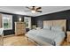 Spacious main bedroom featuring wood floors, ceiling fan, and natural light from large windows at 2256 W Front St, Burlington, NC 27215