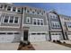 Townhome exterior featuring a white garage door, neutral siding and a black front door at 2313 Bay Minette Sta # 543, Apex, NC 27502