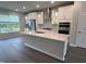 Bright, open kitchen with island, pendant lights, stainless appliances, and gray backsplash at 2313 Bay Minette Sta # 543, Apex, NC 27502