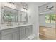 Bright bathroom featuring double vanity with white countertops, gray cabinets, and modern fixtures at 251 Sequoia Dr, Louisburg, NC 27549