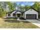 Charming modern farmhouse with white siding, black trim, and a well-manicured lawn at 251 Sequoia Dr, Louisburg, NC 27549