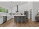 Modern kitchen featuring white cabinets, a stylish island, stainless steel appliances, and wood floors at 251 Sequoia Dr, Louisburg, NC 27549