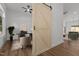 Home office featuring a modern desk setup, stylish seating, and a sliding barn door at 251 Sequoia Dr, Louisburg, NC 27549