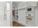 Spacious walk-in closet with built-in shelving, hanging rods and marble flooring at 251 Sequoia Dr, Louisburg, NC 27549