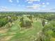 Expansive aerial shot of the golf course surrounded by a neighborhood and mature trees under a blue sky at 2805 Chelsea Cir, Durham, NC 27707