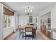 Bright dining room with wood table, six chairs, chandelier, and lots of natural light at 2805 Chelsea Cir, Durham, NC 27707