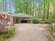 Spacious home with a long driveway leading to a carport, set amidst a backdrop of towering trees at 2805 Chelsea Cir, Durham, NC 27707