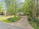 Charming home nestled among mature trees with a long, curved driveway and lush landscaping at 2805 Chelsea Cir, Durham, NC 27707