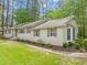 Inviting home showcasing neutral siding, dark shutters, and lush landscaping against a wooded backdrop at 2805 Chelsea Cir, Durham, NC 27707