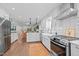 Well-lit kitchen with stainless steel appliances, white cabinets, and an open view to the living room at 2805 Chelsea Cir, Durham, NC 27707