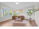 Sunlit office featuring warm wood floors and multiple windows overlooking the landscaped yard at 2805 Chelsea Cir, Durham, NC 27707