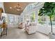 Light-filled sunroom featuring cozy seating, large windows, and a view of the serene backyard at 2805 Chelsea Cir, Durham, NC 27707