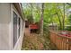 View of backyard features wooden deck with mature trees, playhouse and partial view of additional deck at 2852 Rue Sans Famille, Raleigh, NC 27607