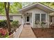 A charming front exterior featuring a white-railed wooden walkway, leading to a covered entrance and glass-paneled door at 2852 Rue Sans Famille, Raleigh, NC 27607