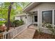 A charming front exterior featuring a white-railed wooden walkway, leading to a covered entrance and glass-paneled door at 2852 Rue Sans Famille, Raleigh, NC 27607
