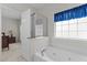 Bathroom featuring jacuzzi tub, white trim and an open door with a view to the bedroom at 292 Joshua Glen Ln, Cary, NC 27519