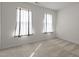 A carpeted bedroom with white walls, natural light, and two windows with curtains at 292 Joshua Glen Ln, Cary, NC 27519
