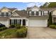 Charming townhouse with a two-car garage, landscaped yard, and classic black shutters and accents at 292 Joshua Glen Ln, Cary, NC 27519