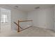 Upstairs hallway with carpet, white walls and a wooden railing, with an adjoining room at 292 Joshua Glen Ln, Cary, NC 27519
