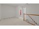 Hallway with carpet and wooden railings leading to a bathroom and bedroom space at 292 Joshua Glen Ln, Cary, NC 27519