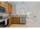 Bright kitchen view to Gathering room with wooden cabinets and stainless steel appliances at 292 Joshua Glen Ln, Cary, NC 27519