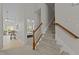 Carpeted staircase with wooden railing leads to the upper level, with views of a sunroom at 292 Joshua Glen Ln, Cary, NC 27519