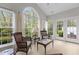 Bright sunroom featuring wicker seating, large windows, and a tranquil outdoor view at 292 Joshua Glen Ln, Cary, NC 27519
