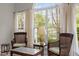 Sunroom view with lake view, wicker seating, marble topped coffee table and elegant lamp at 292 Joshua Glen Ln, Cary, NC 27519
