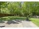 Spacious backyard featuring a lush lawn, mature trees, and a concrete patio at 301 Marsh Landing Dr, Holly Springs, NC 27540