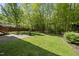 Lush backyard with mature trees, a wooden fence, and a well-manicured lawn at 301 Marsh Landing Dr, Holly Springs, NC 27540