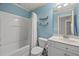 Well-lit bathroom with a shower-tub combo, white vanity, and modern fixtures at 301 Marsh Landing Dr, Holly Springs, NC 27540