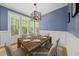 Virtually staged dining room boasts large windows, modern lighting, and hardwood floors, creating an inviting atmosphere at 301 Marsh Landing Dr, Holly Springs, NC 27540