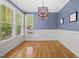 Sun-drenched dining room boasts large windows, modern lighting, and hardwood floors, creating an inviting atmosphere at 301 Marsh Landing Dr, Holly Springs, NC 27540