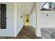 Close up on the front porch, showing its wood floors, white pillars, and a bright yellow front door at 301 Marsh Landing Dr, Holly Springs, NC 27540