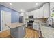 Bright kitchen featuring stainless steel appliances, granite countertops, and a large island, ideal for cooking and entertaining at 301 Marsh Landing Dr, Holly Springs, NC 27540
