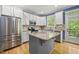 Bright kitchen featuring stainless steel appliances, granite countertops, and a large island, ideal for cooking and entertaining at 301 Marsh Landing Dr, Holly Springs, NC 27540