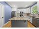 Bright kitchen featuring stainless steel appliances, granite countertops, and a large island, ideal for cooking and entertaining at 301 Marsh Landing Dr, Holly Springs, NC 27540