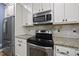 Close up of a modern kitchen featuring stainless steel appliances and granite countertops, perfect for cooking at 301 Marsh Landing Dr, Holly Springs, NC 27540