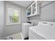 Efficient laundry room with modern washer and dryer and storage at 301 Marsh Landing Dr, Holly Springs, NC 27540