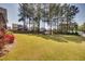 Extensive backyard showing a wide expanse of lawn, mature trees in the background, and garden beds in the corner at 3037 Freeman Farm Way, Rolesville, NC 27571
