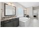 Bright bathroom featuring a granite countertop, dark cabinets, and a tub at 3037 Freeman Farm Way, Rolesville, NC 27571
